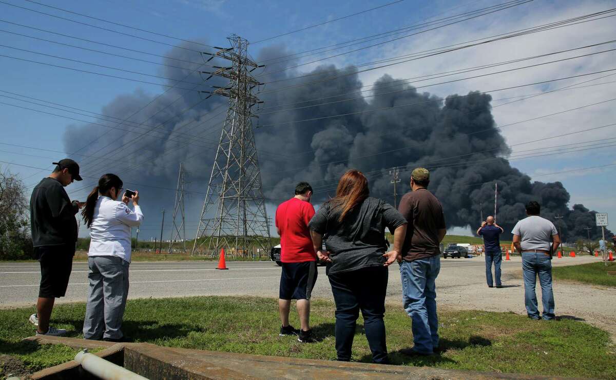 People gather to watch as firefighters continue to battle the petrochemical fire at Intercontinental Terminals Company, which grew in size due to a lack of water pressure, on March 19, 2019, in Deer Park, Texas.