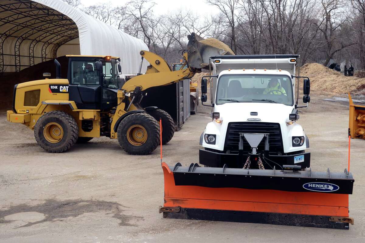 A payloader loads sand into a waiting Department of Public Works truck in Milford, Conn. Jan. 28, 2022.