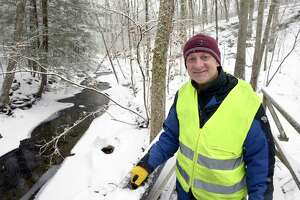 James Wistman has been making repairs and maintaining the Brooklands Trail in Sherman, Conn. Recently he replaced steps coming off a bridge on the trail, including crafting a step from half a log. Thursday, January 20, 2022.