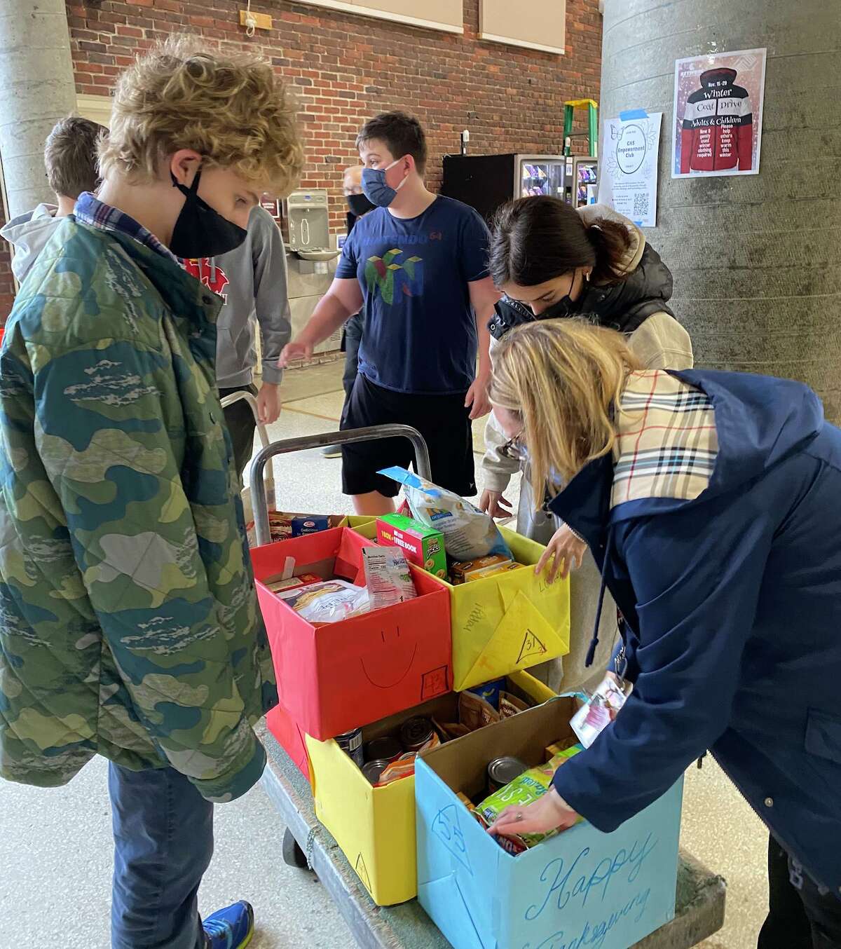 Greenwich High School teacher Kathy Mendez, at right in blue jacket, works with some of her ninth-grade students to pack boxes of food for delivery to community members in need for Thanksgiving on Nov. 22, 2021.
