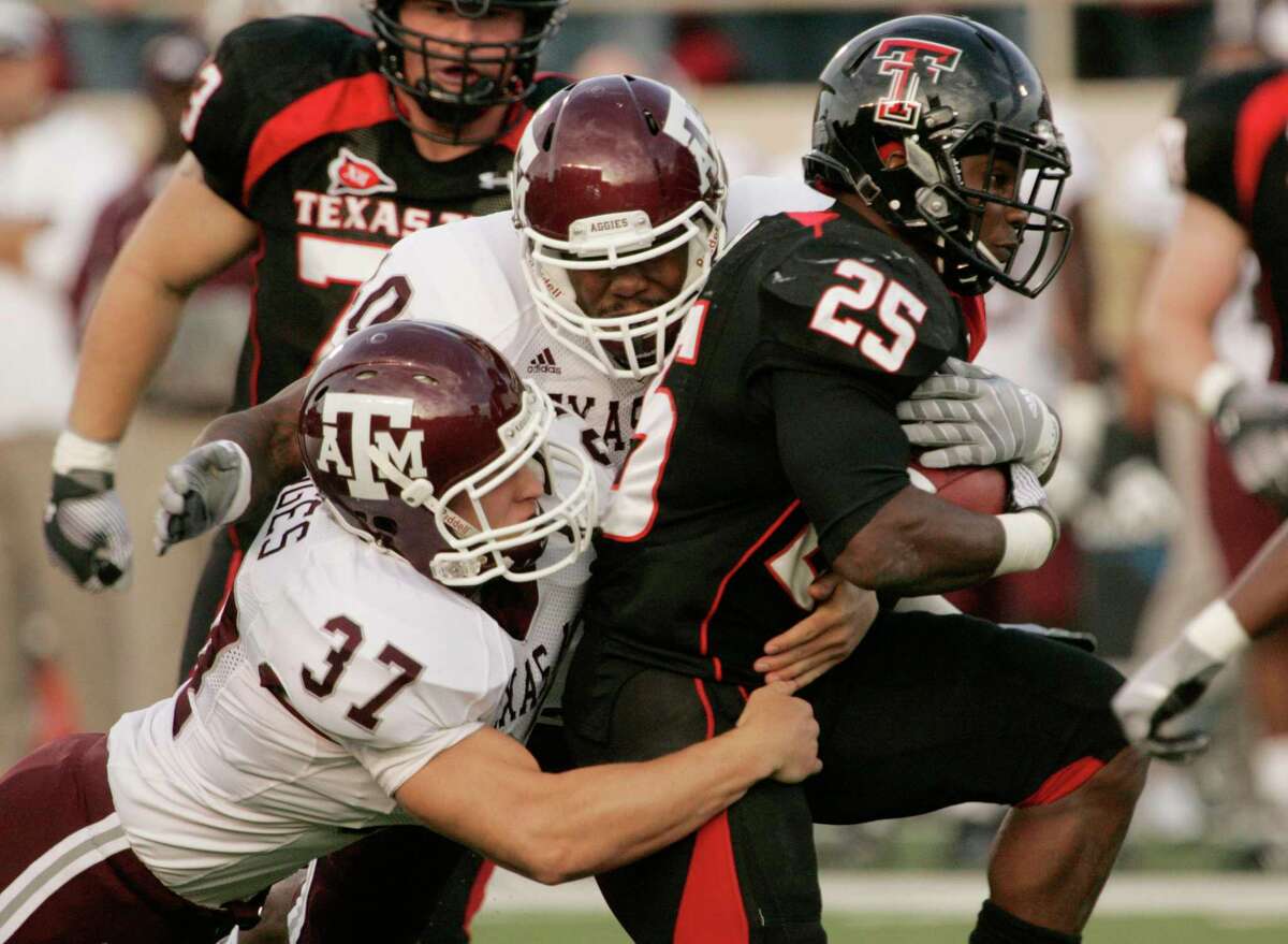 Texas Tech running back Baron Batch (25) gets tackled by Texas A&M defenders Michael Hodges (37) and Von Miller (40) during the first quarter of an NCAA college football game in Lubbock, Texas, Saturday, Oct. 24, 2009. (AP Photo/Mike Fuentes)