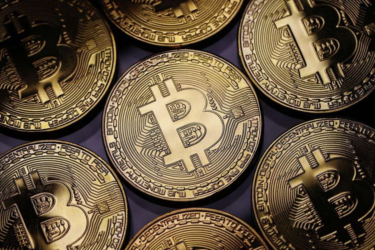 Bitcoin tokens are symbolic since the cryptocurrency itself really exists only digitally. But the rapid growth of crytpo currency mining in Texas is raising concerns about the massive amounts of energy the operations require and greenhouse gases they prodcu (Dan Kitwood/Getty Images/TNS)