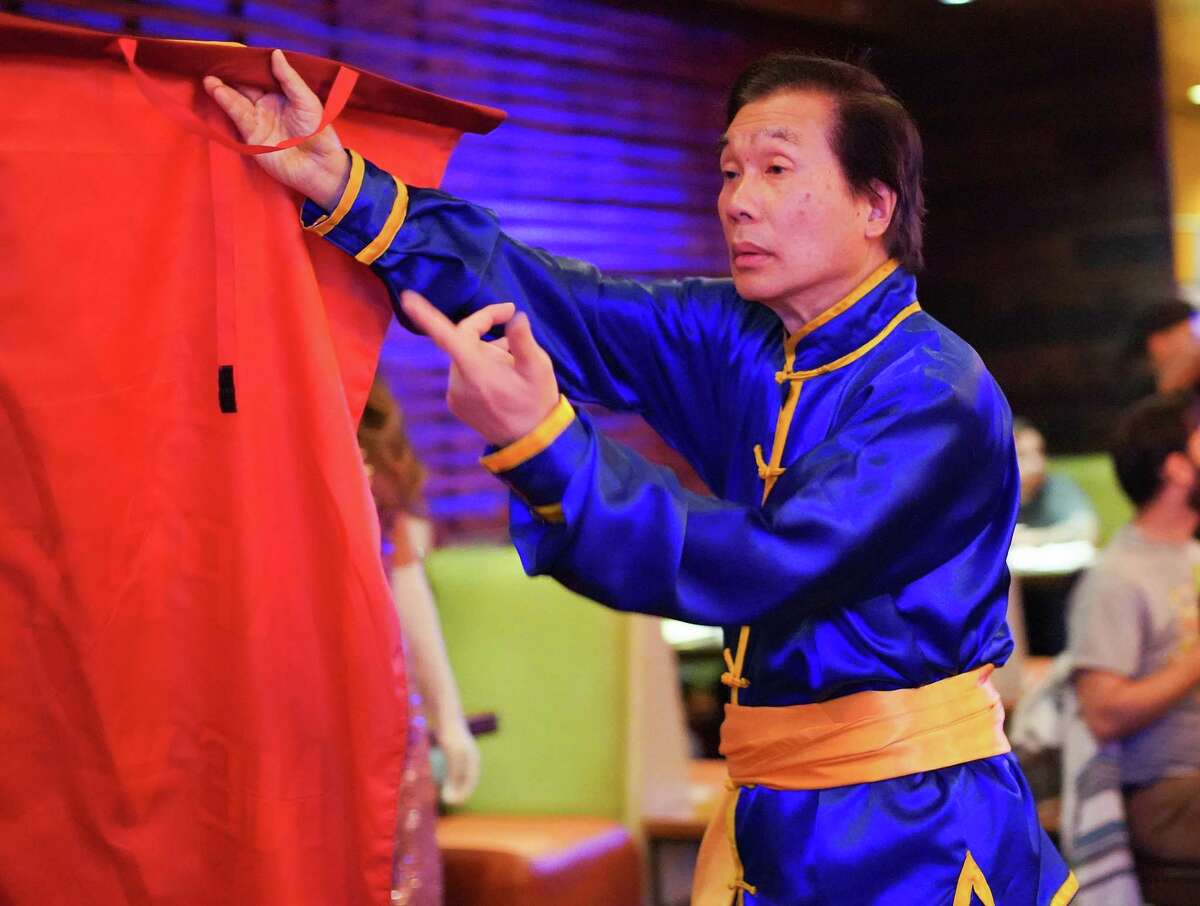 Allen Lee, owner of Lee’s Golden Dragon, grabs a new year banner after a lion dance performance at Mikoto in Houston on Thursday, Jan. 27, 2022.