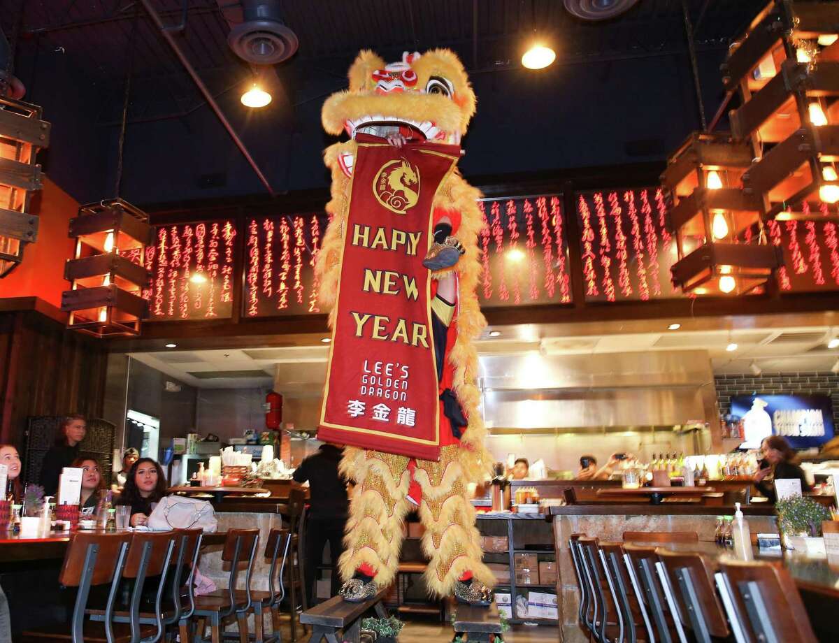 Lion dancers hold up a Lunar New Year banner at the end of a performance at Mikoto in Houston on Thursday, Jan. 27, 2022.