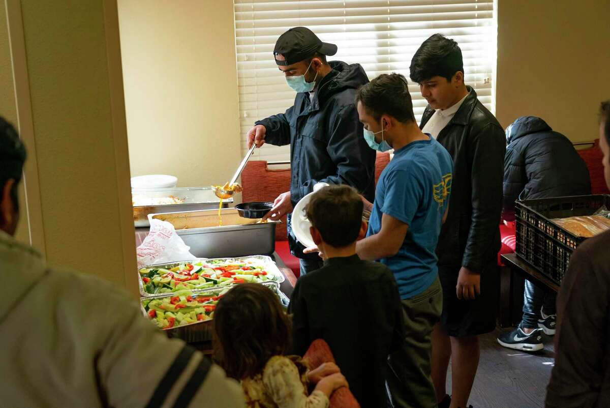 A meal provided by The Afghan Village Restaurant is shared among families in the common area of ​​an extended stay motel, Friday, Jan. 28, 2022, in Fort Bend County.