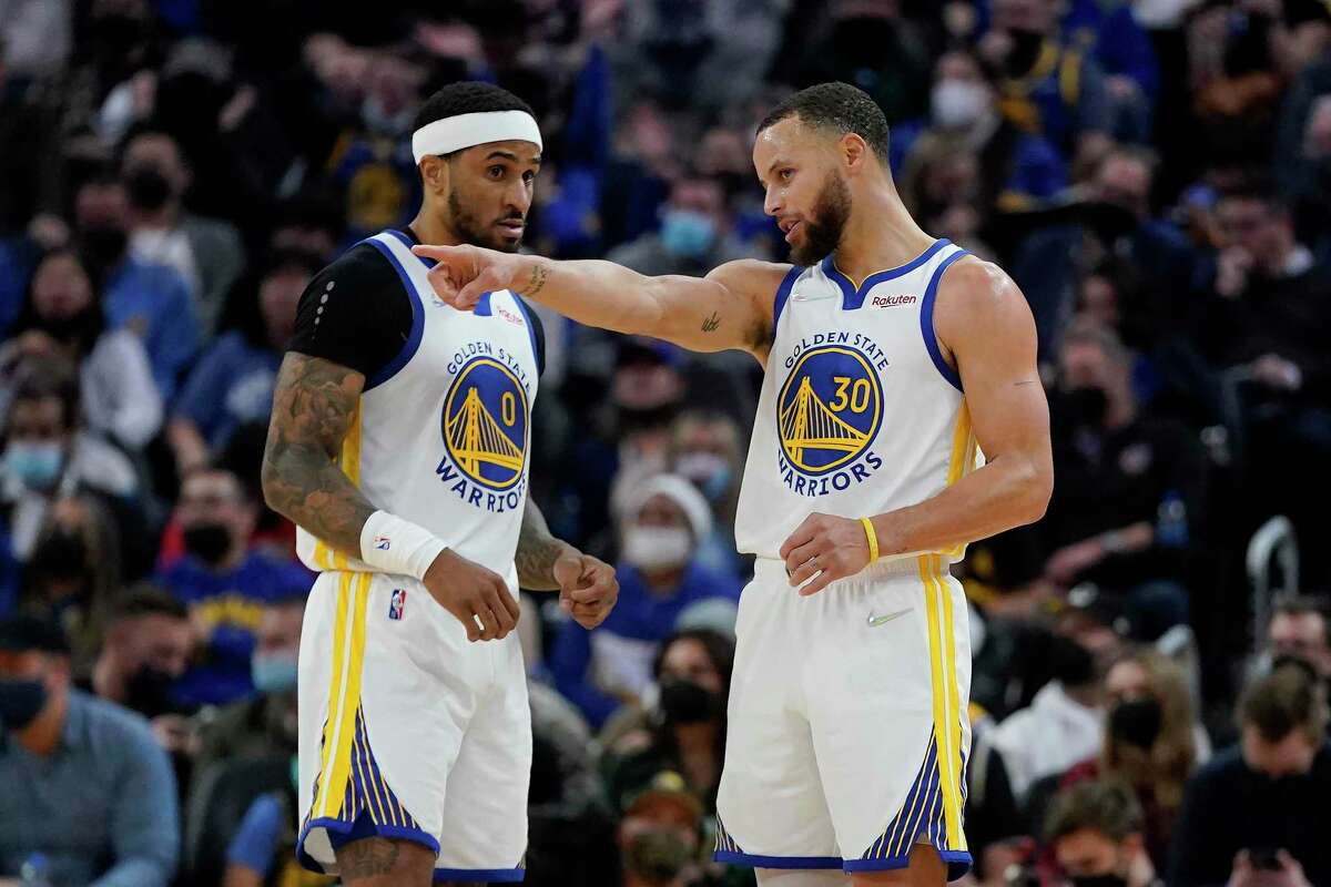 Golden State Warriors guard Gary Payton II (0) talks with guard Stephen Curry (30) against the Houston Rockets during an NBA basketball game in San Francisco, Friday, Jan. 21, 2022. (AP Photo/Jeff Chiu)