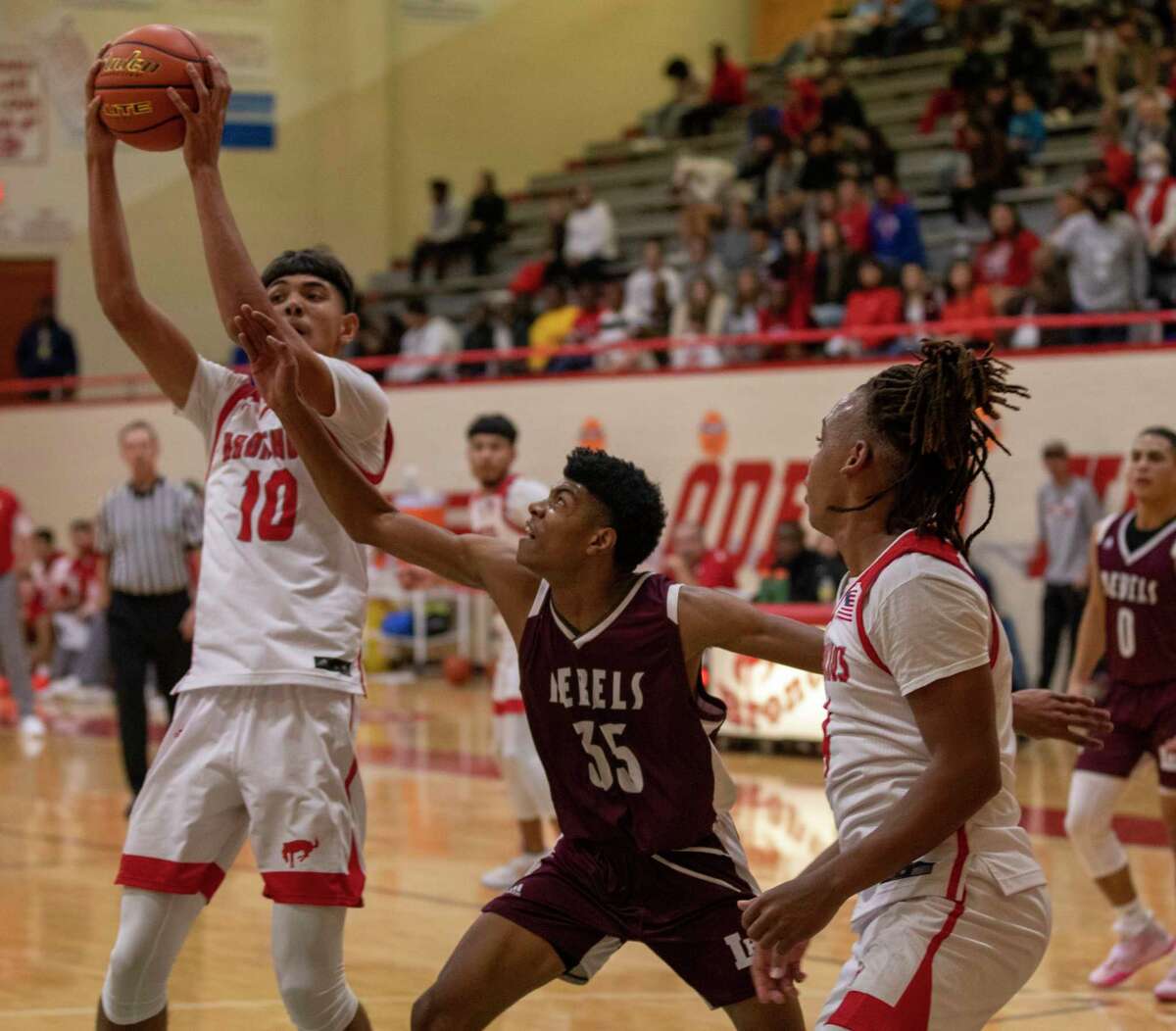 Odessa High’s Ivan Carreon (10) rebounds the ball as Legacy’s Brandon Foster lunges for the ball Friday, Jan. 28, 2022 at Odessa High Fieldhouse. Jacy Lewis/Reporter-Telegram
