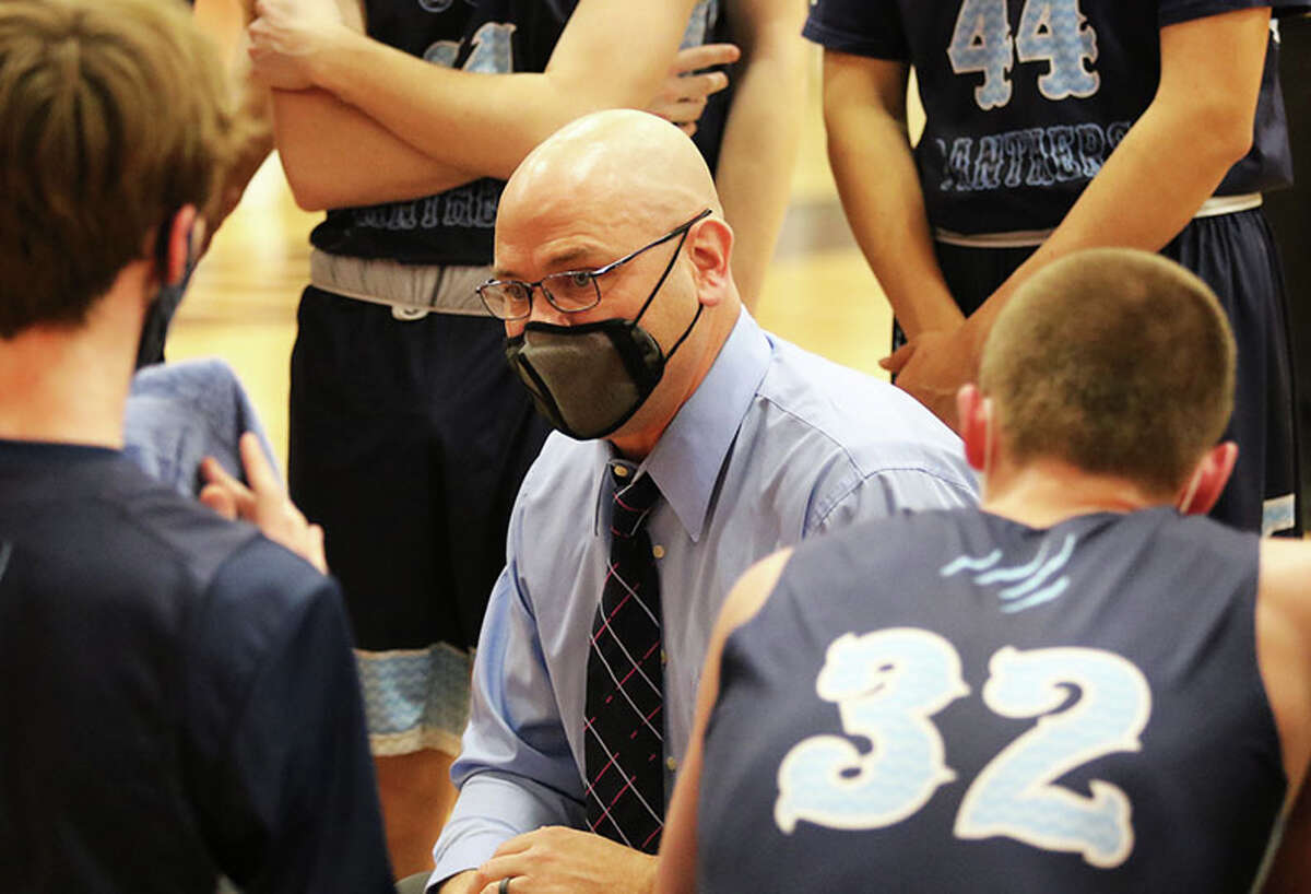 Jersey coach Stote Reeder (middle) talks with his team during a break in Friday's MVC game in Highland.