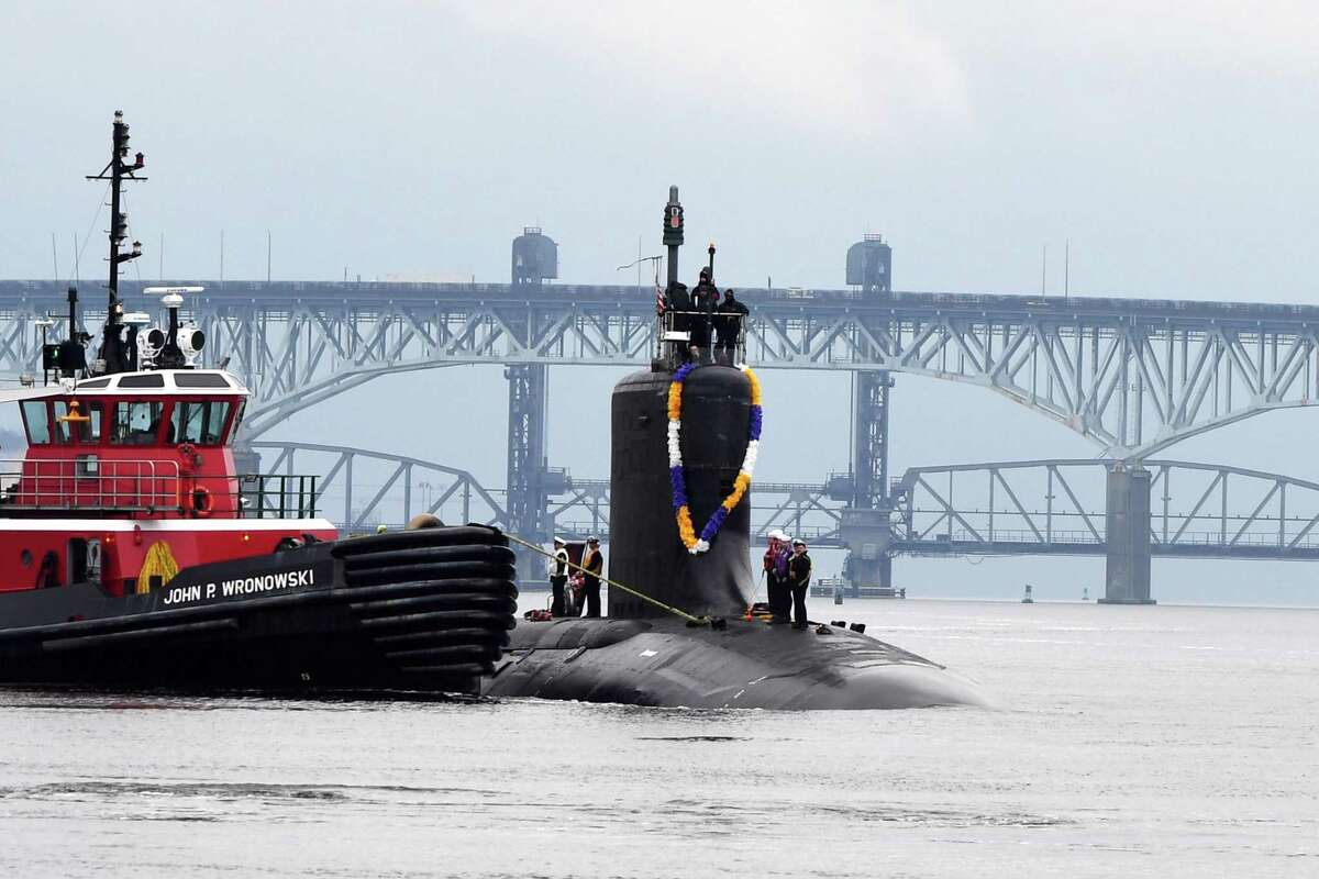 The Virginia-class submarine USS Minnesota heads up the Thames River in November 2021 toward Naval Submarine Base New London in Groton, Conn. The Electric Boat subsidiary of General Dynamics is readying to bid on the SSN(X) attack sub program that the U.S. Navy wants to replace Virginia-class boats as they reach retirement in the coming decades. Huntington Ingalls Industries, which delivered the Minnesota in 2013, is also expected to bid for the SSN(X) program.