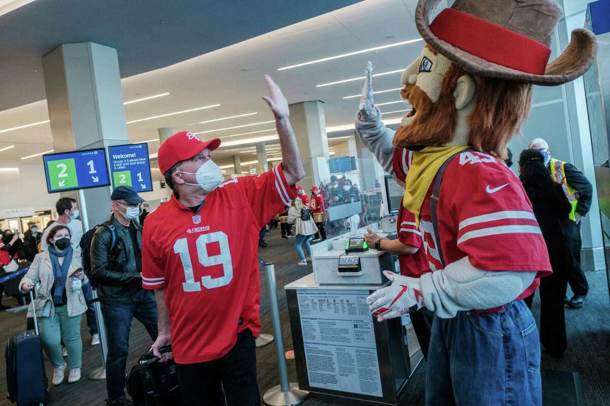Sourdough Sam, the 49ers team mascot, high-fives a passenger during a pep rally at San Francisco International Airport.