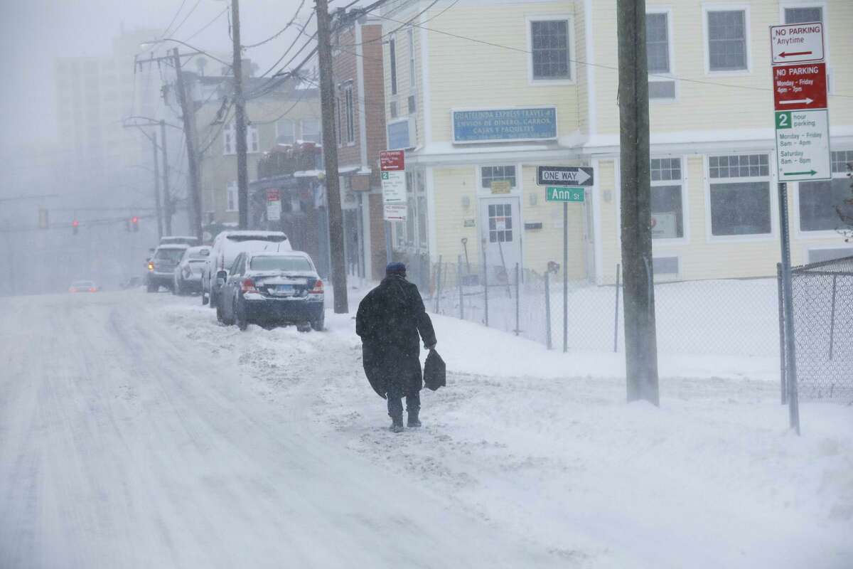A person tries to navigate through the snow during Saturday’s nor’easter on Stamford’s West Side.