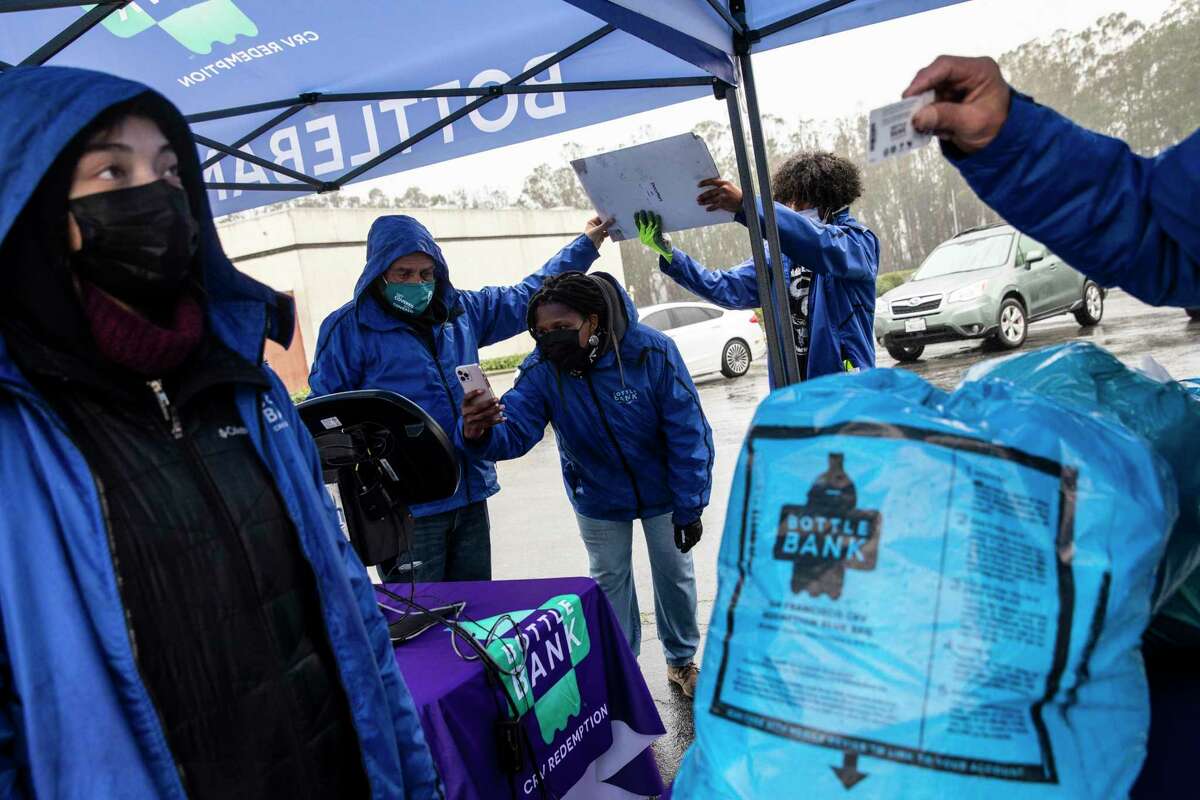 Marria Evbuoma (center), recycling director with the San Francisco Conservation Corps, takes a photograph of a mobile kiosk during a demonstration of the city’s BottleBank mobile recycling program at Stonestown Galleria in December.