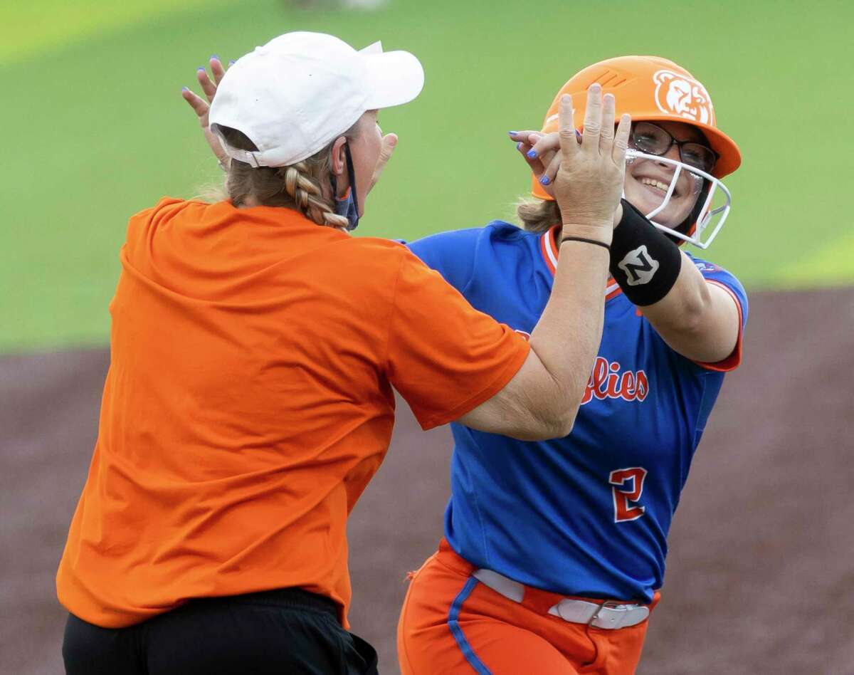 Allie Hagebusch #2 of Grand Oaks high-fives head coach Amanda Brimberry after she hits a homerun during the second inning of a Region II-6A quarterfinal one-game playoff against Bridgeland at Tomball Memorial High School, Friday, May 14, 2021 in Tomball.