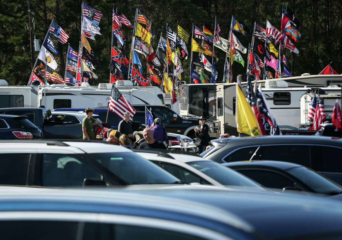 People wait in a parking lot before a Save America rally with former President Donald Trump on Saturday, Jan. 29, 2022, at the Montgomery County Fairgrounds in Conroe.