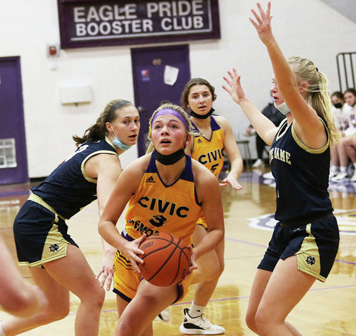 CM's Kelbie Zupan (middle) splits QND defenders Abbey Schreacke (left) and Lia Quintero on a drive through the lane in the first half  Saturday afternoon in Bethalto.