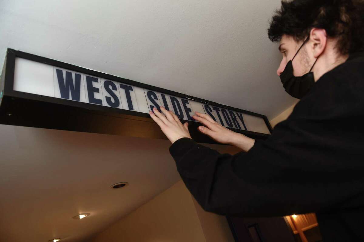 Andrew Esposito arranges the letters for the movie, West Side Story, on the reopening day at the renovated Madison Cinemas, formerly Madison Art Cinemas, on Main Street in Madison on January 28, 2022.