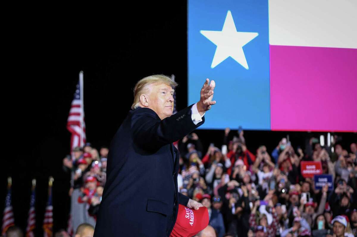 Former President Donald Trump tosses hats to the crowd as he takes the stage during a Save America rally Saturday, Jan. 29, 2022, at the Montgomery County Fairgrounds in Conroe.