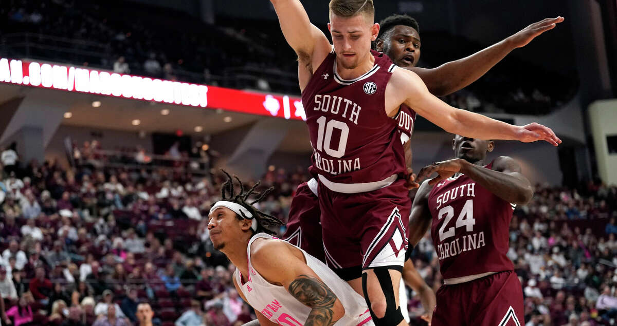 Texas A&M forward Ethan Henderson, left, looks to shoot against South Carolina guard Erik Stevenson, top front, during the first half of an NCAA college basketball game Saturday, Jan. 29, 2022, in College Station, Texas. (AP Photo/Sam Craft)
