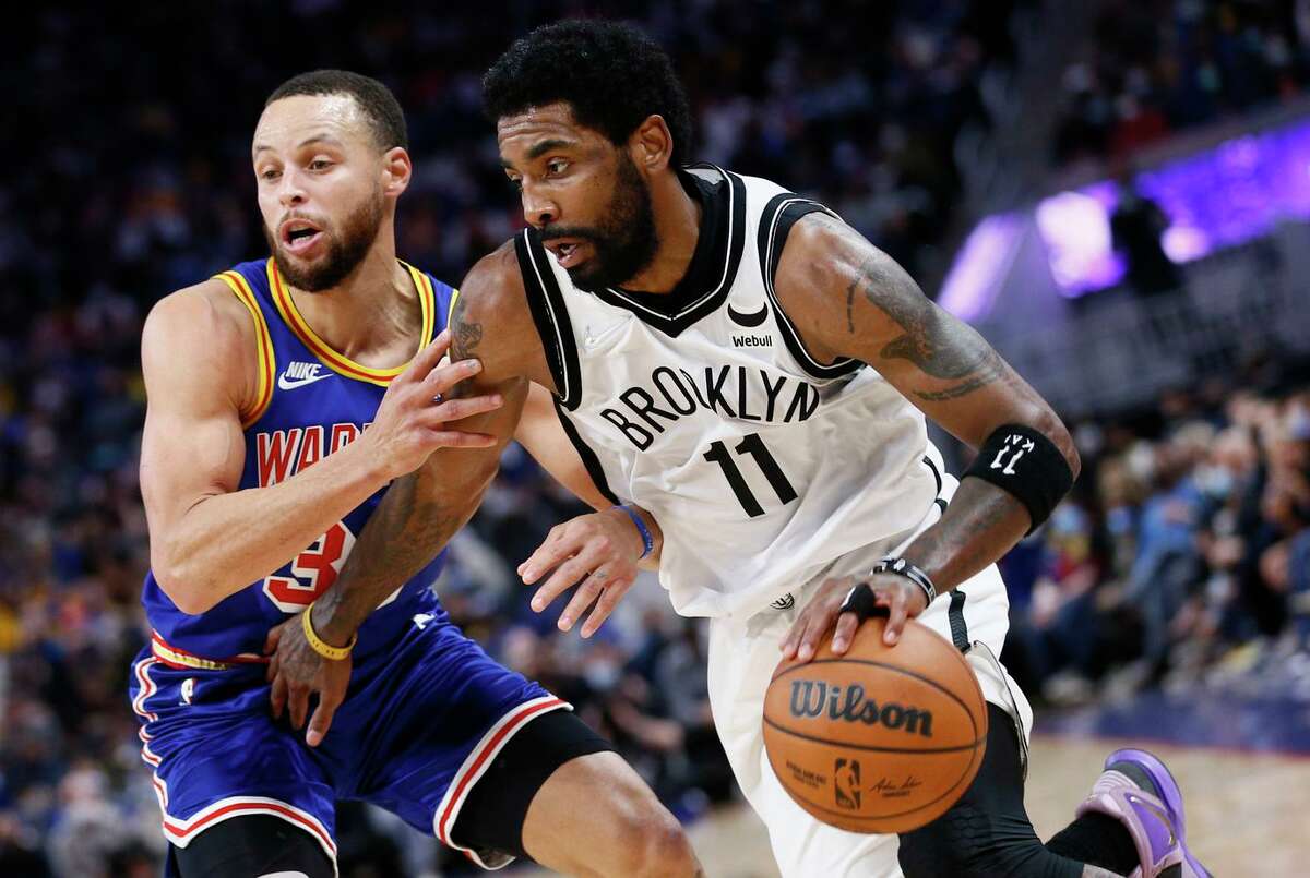 Nets guard Kyrie Irving dribbles against the defense of Warriors guard Stephen Curry. Golden State limited New Jersey to shooting 39.8% from the field on Saturday.