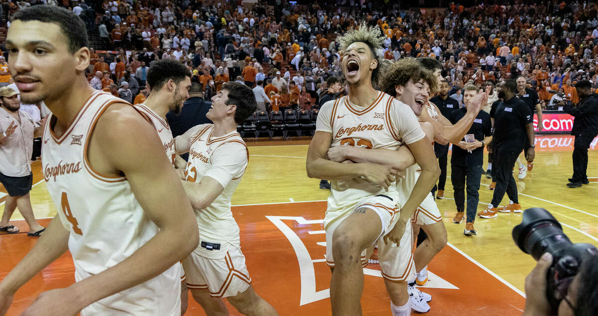 Texas forward Tre Mitchell, center, and guard Devin Askew, right, celebrate a win over Tennessee in an NCAA college basketball game Saturday, Jan., 29, 2022, in Austin, Texas. (AP Photo/Stephen Spillman)