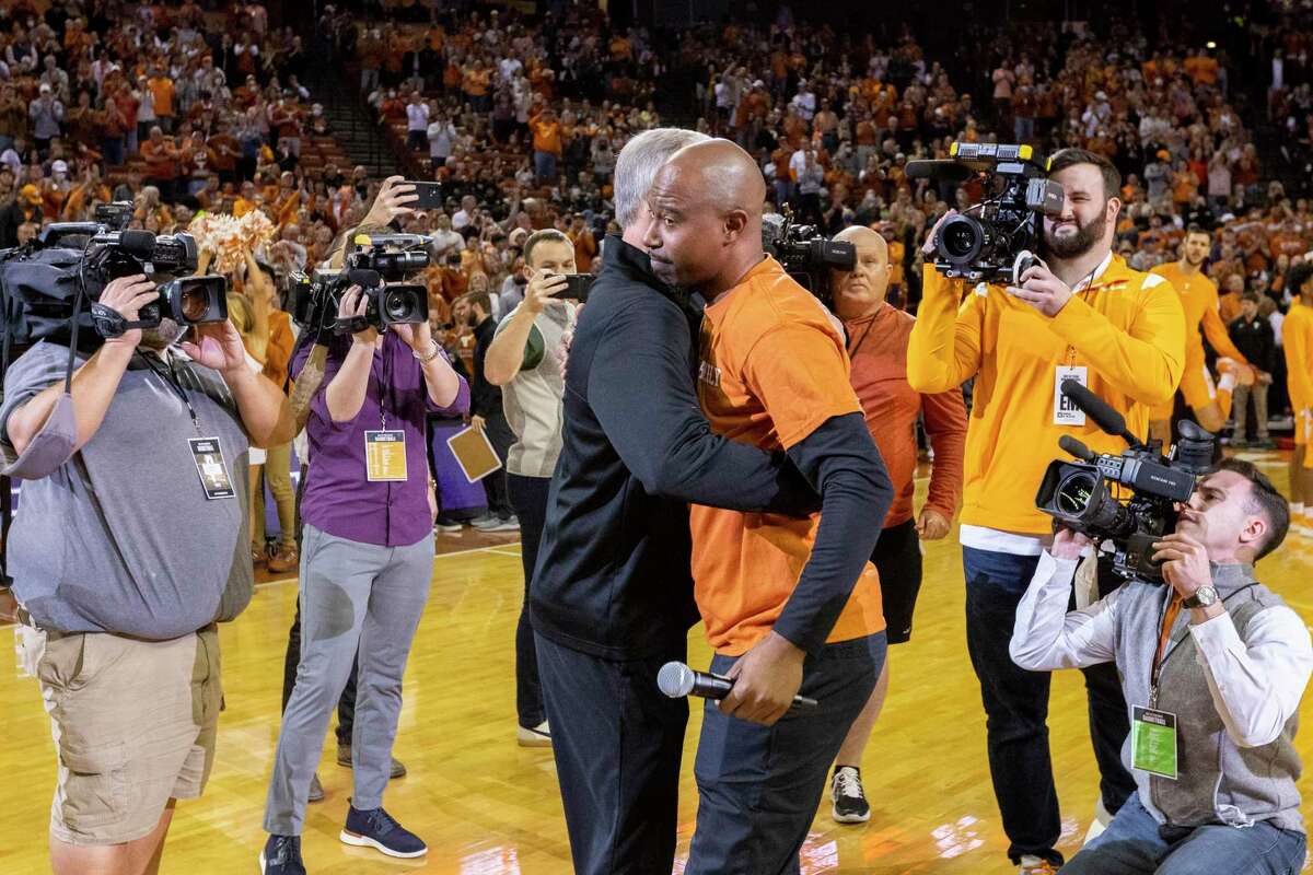 Former NBA guard T.J. Ford, center right, embraces Tennessee head coach Rick Barnes, center left, former Texas head coach, before an NCAA college basketball game between Texas and Tennessee, Saturday, Jan., 29, 2022, in Austin, Texas. (AP Photo/Stephen Spillman)