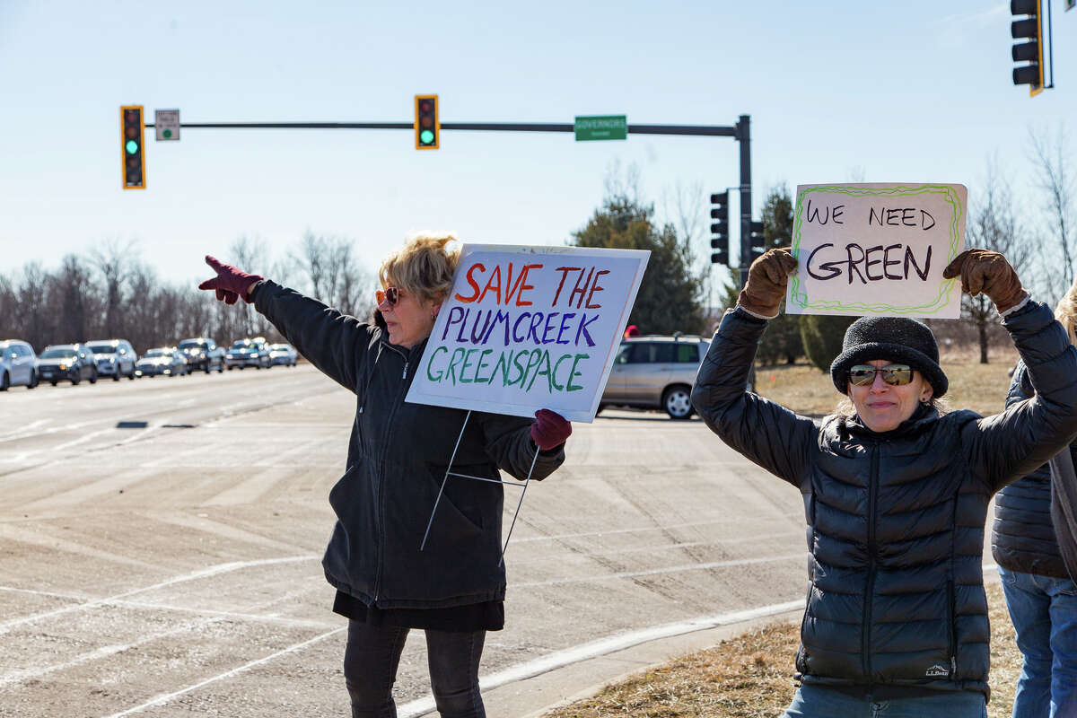Dr. Carole Frick and Dr. Julie Zimmermann of SIUE show support for preserving green space in Madison County during a demonstration Saturday in Edwardsville. 