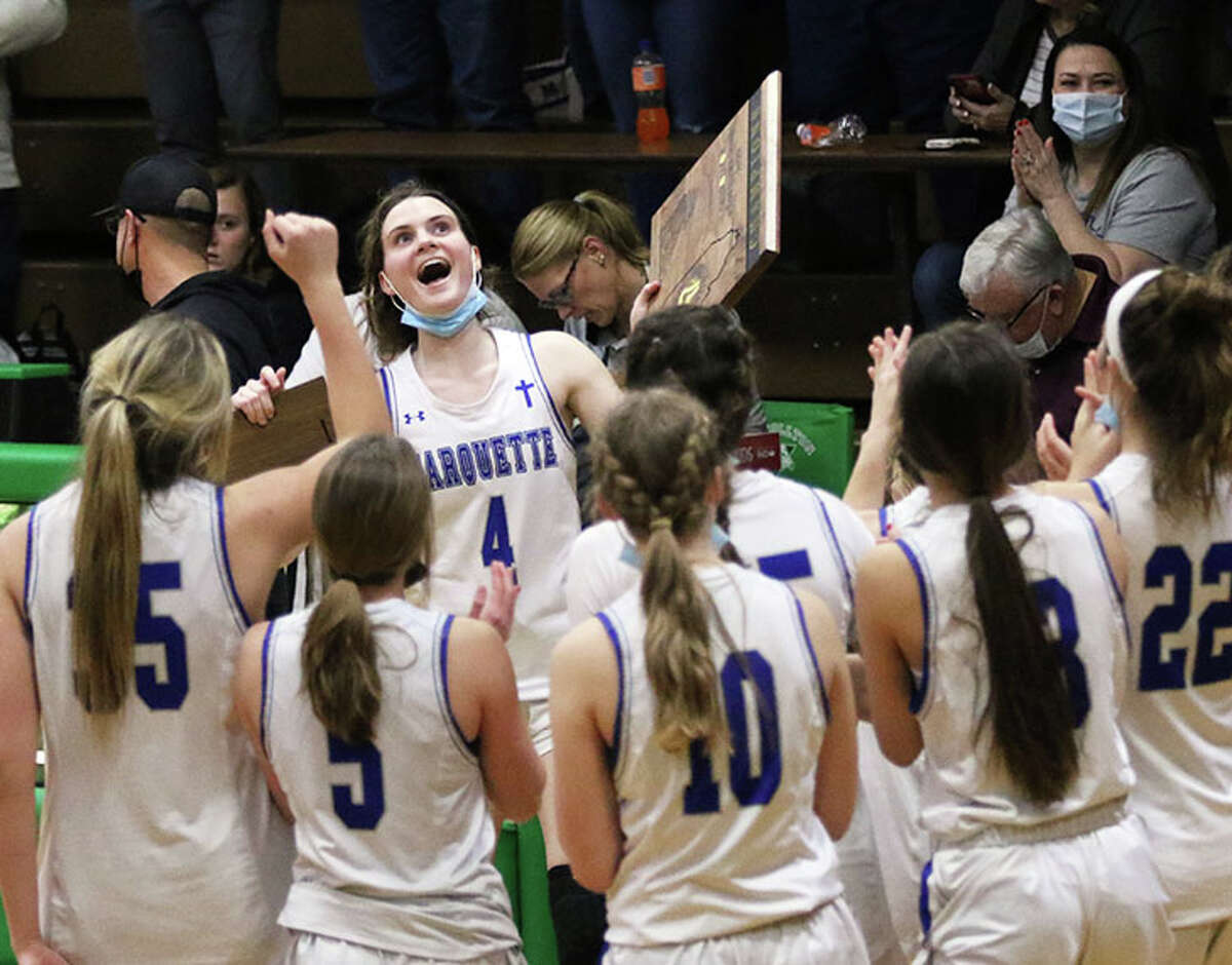 Marquette Catholic's Abby Williams (4) brings the championship plaque to her teammates Saturday night after the Explorers the 47th Lady Hawk Invite in Carrollton.