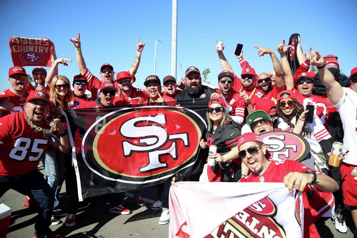 Alvin Caampued (center third from left), Anthony Ancheta (center fourth from left), and Scott Moffat (center fifth from left), who traveled with a contingent of friends from the San Francisco Bay Area, tailgate before the NFL NFC Championship game between the Los Angeles Rams and the San Francisco 49ers at SoFi Stadium in Inglewood, Calif., on Sunday, January 30, 2022.