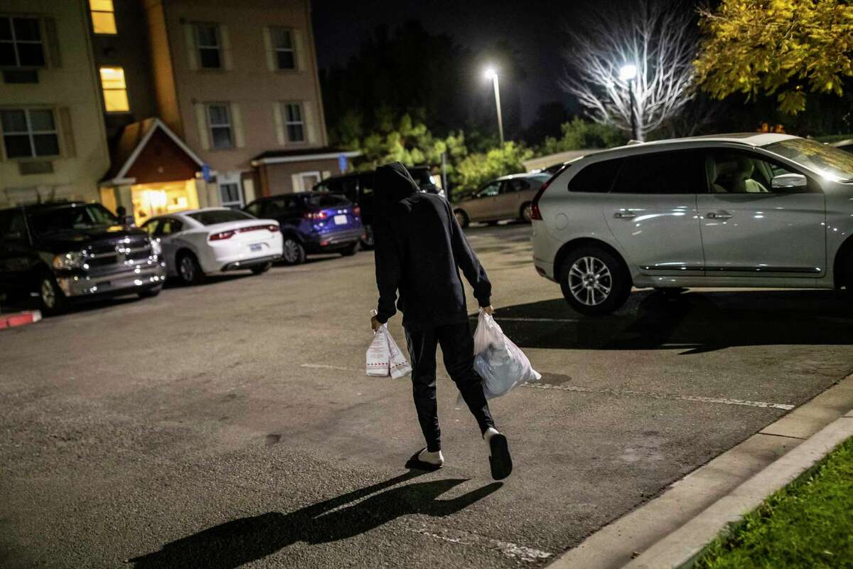 Raymond Belcher, 15, carries dinner and clean laundry back to an extended-stay hotel in Newark.