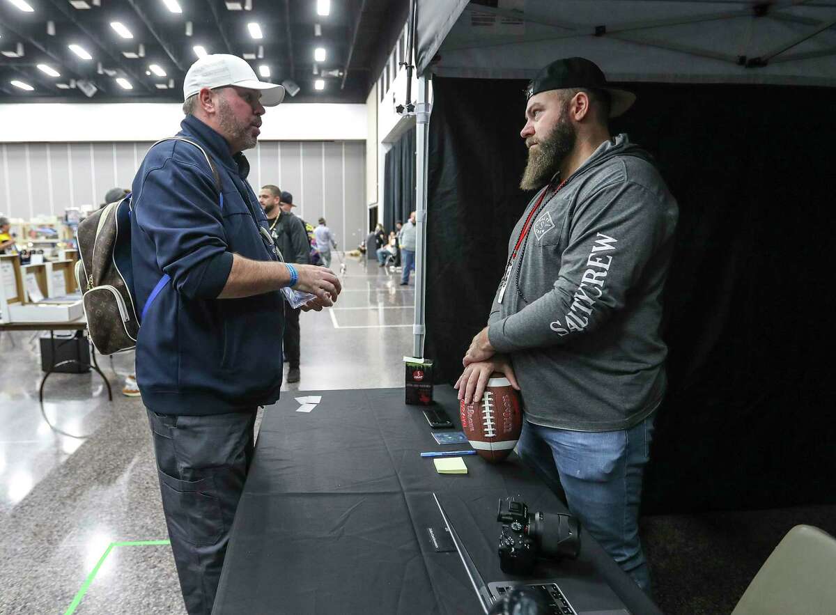 Bradley Crenshaw, Founder of DCI (Dallas Card Investors) talks with Troy Weatherford, left, at the booth during the third annual Fiterman Sports Autograph Show of Texas at the Pasadena Fairgrounds Convention Center on Sunday, Jan. 30, 2022 in Pasadena. Dallas Card Investors helps collectors submit trading cards to CSG for certification.