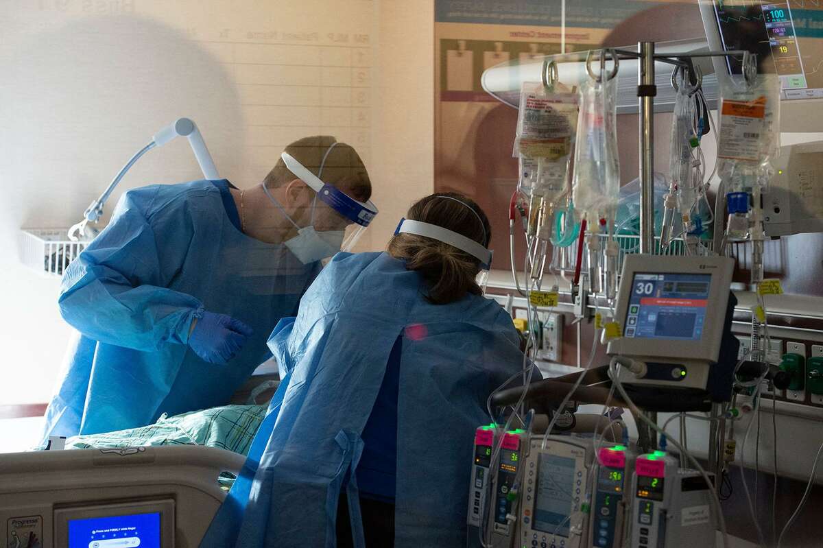 Medical workers treat a patient who is suffering from the effects of COVID-19 in the ICU at Hartford Hospital in Hartford, Connecticut, on Jan. 18, 2022.