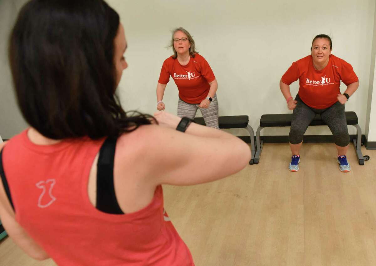 Donna Honsinger of Clifton Park, left, and Rebecca Atwell of North Greenbush perform squats as they get assessed by Theresa Petrone Butts, co-chair of Better U, left, at SEFCU. Better U is a free three-month program the American Heart Association hosts for women who want to improve their heart health.