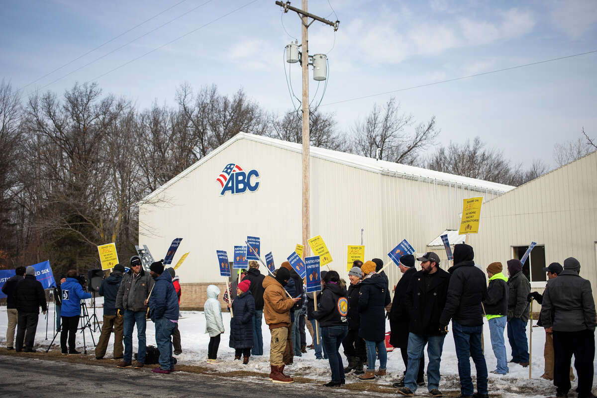 About 100 people gather in support of six former workers of United Electrical Contractors who have filed a lawsuit alleging racist treatment on job sites, Tuesday, Feb. 1, 2022 outside of the Associated Builders and Contractors Greater Michigan Chapter in Midland.
