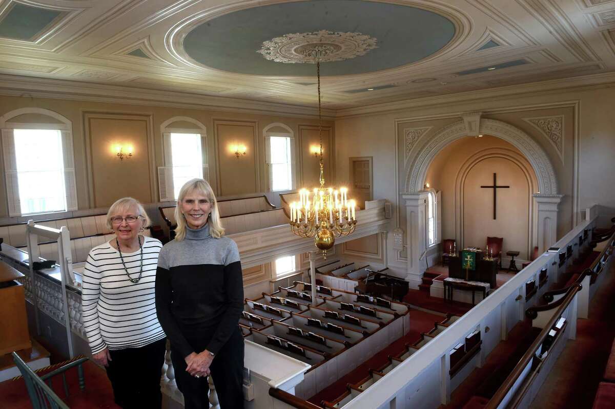 Sanctuary Fund fundraisers Joyce Simpson, left, and Nancy Dickgiesser inside the First Church of Christ in Woodbridge on Jan. 27, 2022. The ceiling has been painted in the trompe l’oeil style to appear three-dimensional as part of the restoration of the church.