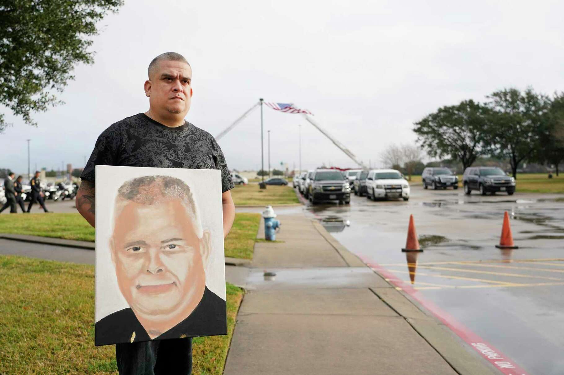 Sergio Martinez holds a memorial portrait he painted of Harris County Constable Precinct 5 Corporal Charles Galloway as he waits to go into the funeral for Corporal Galloway at Second Baptist Church West Campus, 19449 Katy Freeway, Tuesday, Feb. 1, 2022 in Houston. Martinez said he wants to give the painting to the family. Corporal Galloway was fatally shot during a traffic stop in southwest Houston on Jan. 23.