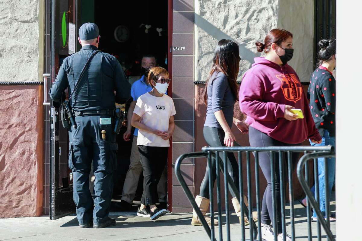 Police officers guide what appears to be employees outside of Kume Spa as they assess the scene of a shooting on Tuesday, Feb. 1, 2022 in Oakland, Calif. Two people, employees of the spa, were in critical condition following the shooting, according to police.
