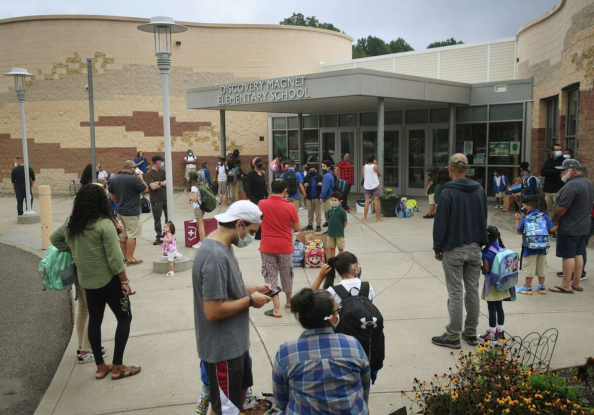 Students and parents wait for doors to open on the first day of school at Discovery Magnet Elementary School in Bridgeport, Conn. on Monday, Aug. 30, 2021.