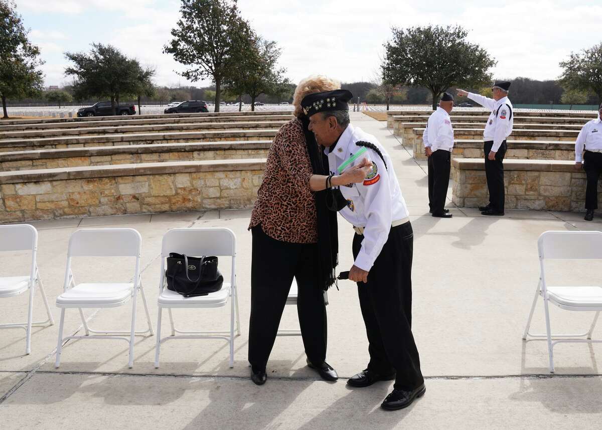 Rick Davila, 82, of the Fort Sam Houston National Cemetery Memorial Services Detachment gets a hug from Carolyn Casas during an event to honor Davila for 30 years of service during veteran burials.