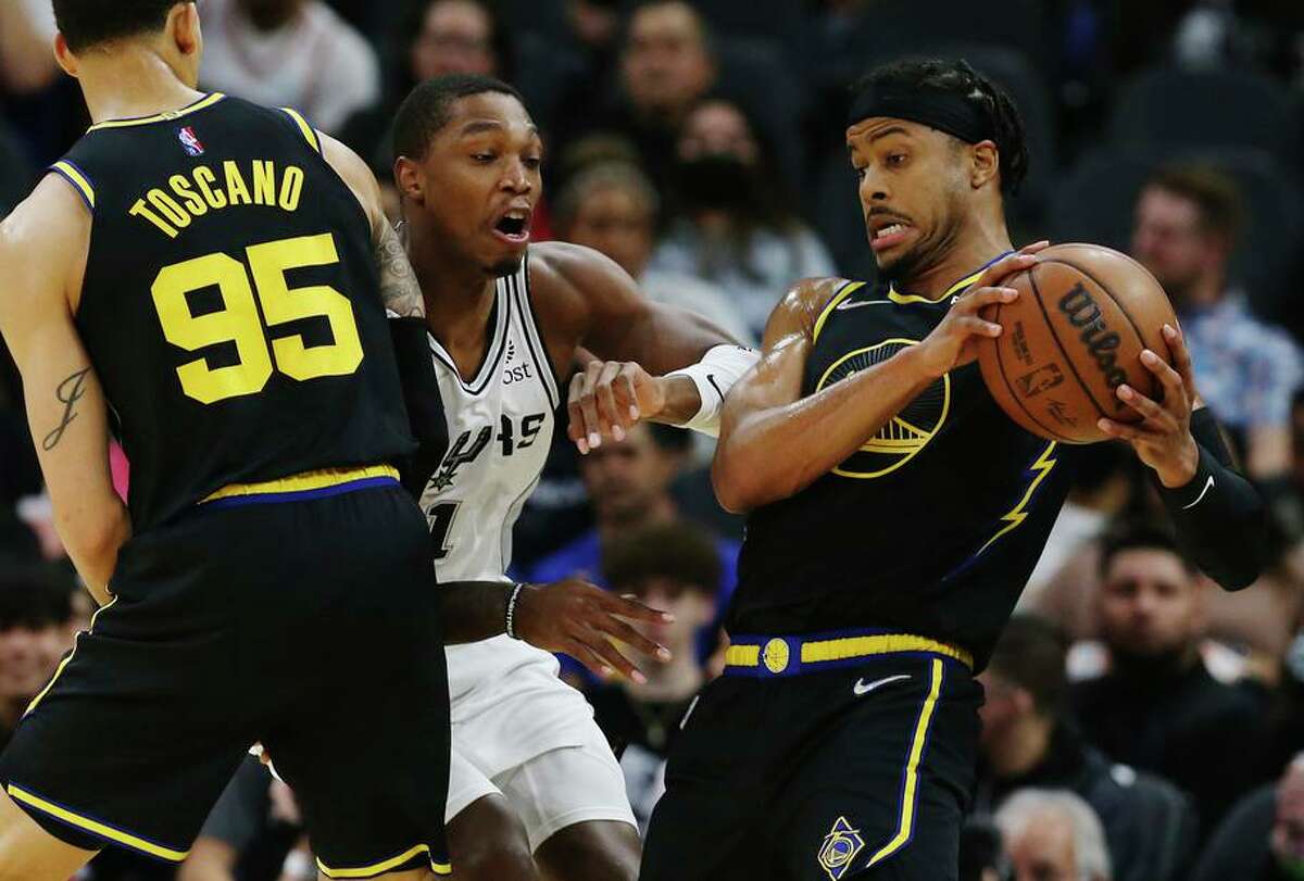 Spurs' Lonnie Walker, IV (01) fights through a screen to defend against Golden State Warriors' Moses Moody (04) during the first half of the game at the AT&T Center on Tuesday, Feb. 1, 2022.