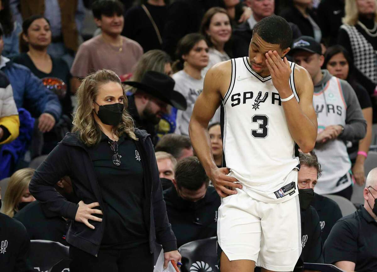 Spurs' Keldon Johnson (03) stands on the sidelines with assistant coach Becky Hammon (left) after leaving the game due to a contact lens issue against the Golden State Warriors during the second half of the game at the AT&T Center on Tuesday, Feb. 1, 2022. Warriors rally late in the game to defeat the Spurs, 124-120.