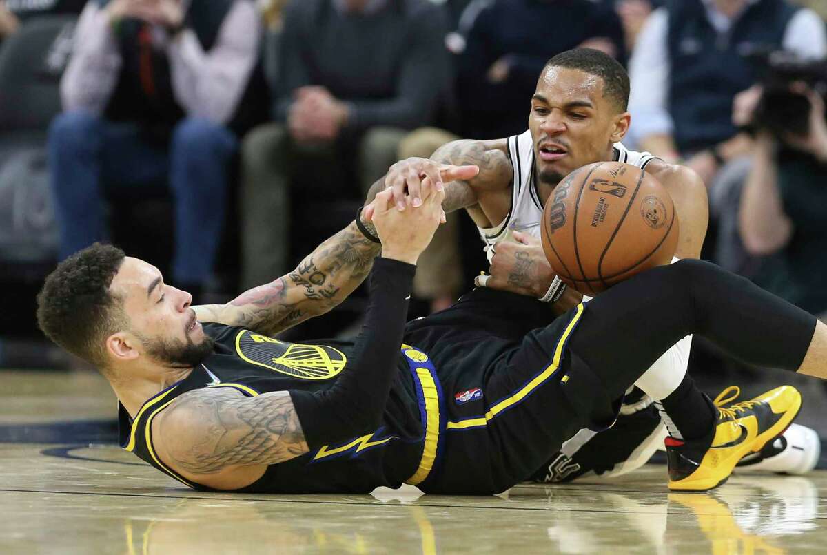 Spurs' Dejounte Murray (05) battles for a rebound against Golden State Warriors' Chris Chiozza (02) during the second half of the game at the AT&T Center on Tuesday, Feb. 1, 2022. Warriors rally late in the game to defeat the Spurs, 124-120.