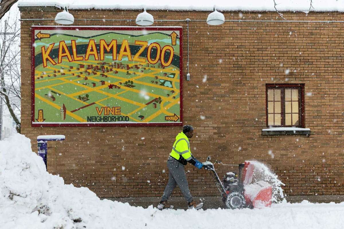 David Jones who runs Kadesh Services clears snow from a sidewalk in the Vine neighborhood of Kalamazoo, Mich., on Wednesday, Feb. 2, 2022. A major winter storm with millions of Americans in its path brought a mix of rain, freezing rain and snow to the middle section of the United States as airlines canceled hundreds of flights, governors urged residents to stay off roads and schools closed campuses. (Joel Bissell (Joel Bissell/Kalamazoo Gazette via AP)