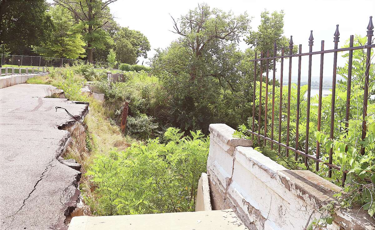 John Badman|The Telegraph Riverview Drive, which is in the process of being reclaimed by nature, collapsed due to erosion from heavy rains back in 2019. In July 2021 officials said the project was almost ready to be bid; six months later design work for the project has yet to be completed.