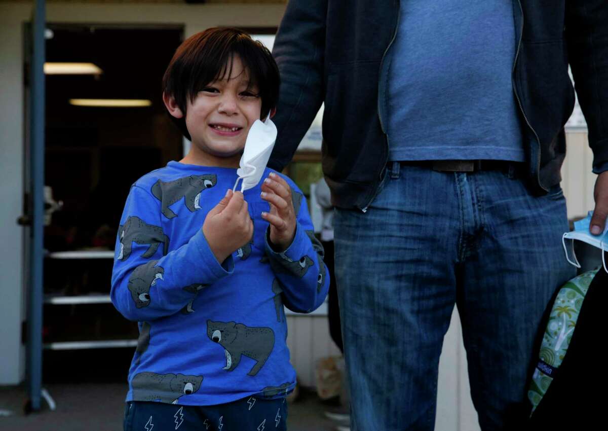 Ernesto Falcon picks up his son, Gabriel from Madera Elementary on Tuesday, Feb. 1, 2022, in El Cerrito , Calif. Falcon allows his son to take off his mask once he’s outside his afterschool program as he would like to see masking outside no longer required for kids at school.