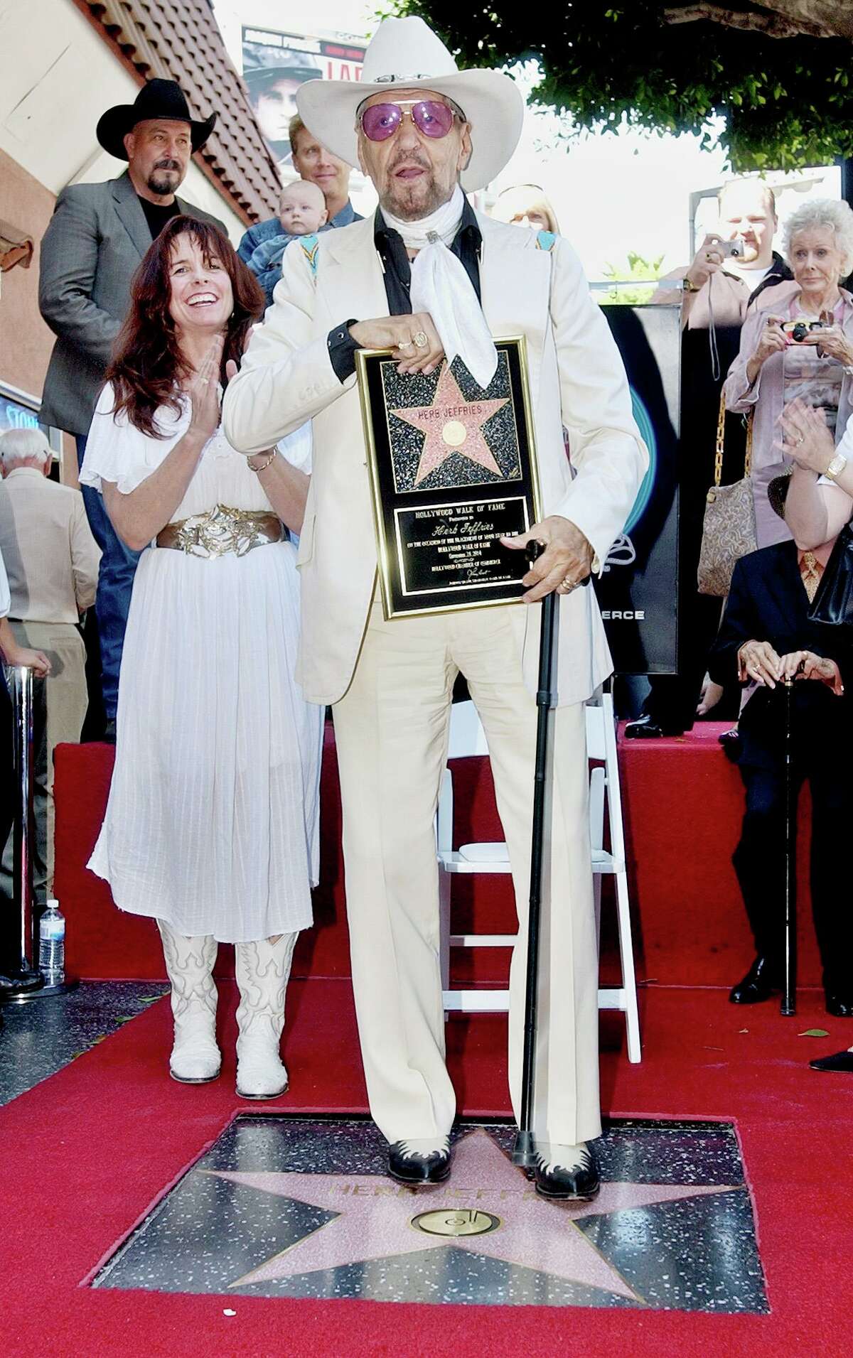 Herb Jeffries, a singing cowboy hero of the silver screen, along with his wife Savannah, left, takes the first step on his new star along the Walk of Fame in the Hollywood section of Los Angeles, following dedication ceremonies on his 93rd birthday, Friday, Sept. 24, 2004. Jeffries was known as the "Bronze Buckaroo," the hero of a string of all-black musical Westerns in the 1930s, and also was an original member of the Duke Ellington Orchestra and the singer on the band's hit songs "Flamingo" and "Satin Doll" from the 1940s on. (AP Photo/Reed Saxon)