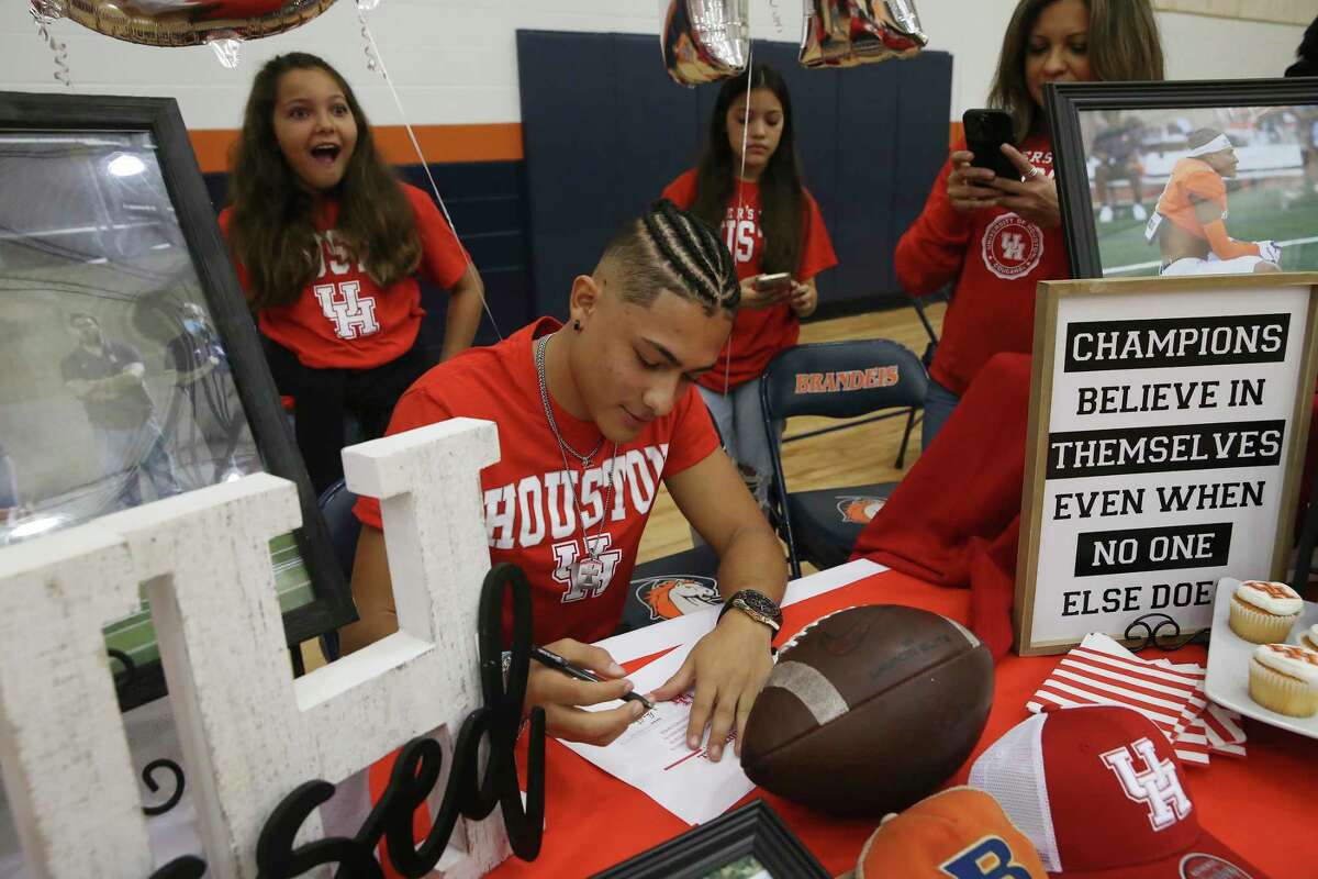 With his family watching, Brandies cornerback Aiden Inesta-Rodriguez works on his paperwork to be a preferred walk-on at the University of Houston.