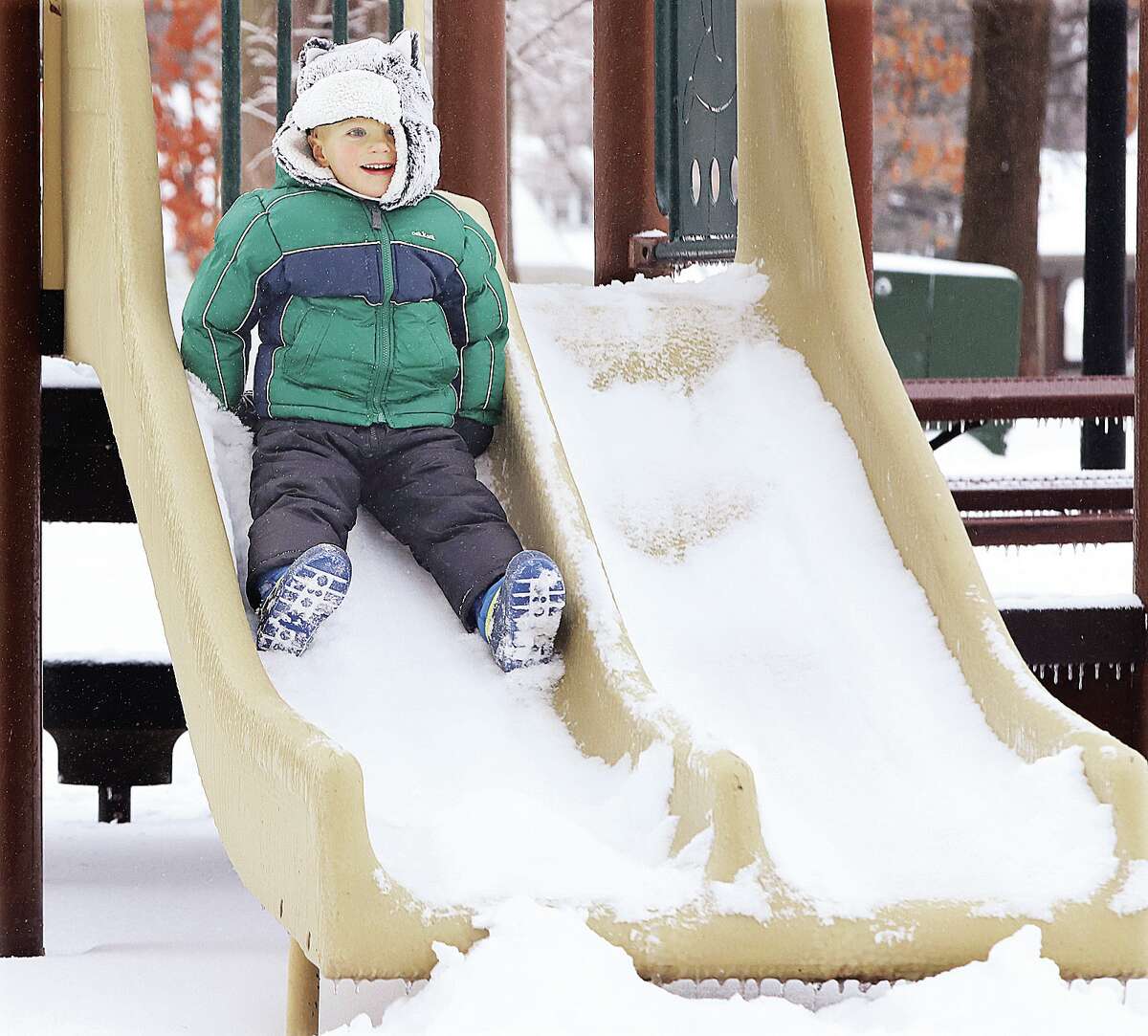 Jack Spohr, 3, of Edwardsville, seemed to really enjoy riding down the snow covered playground slide at Leclaire Park.