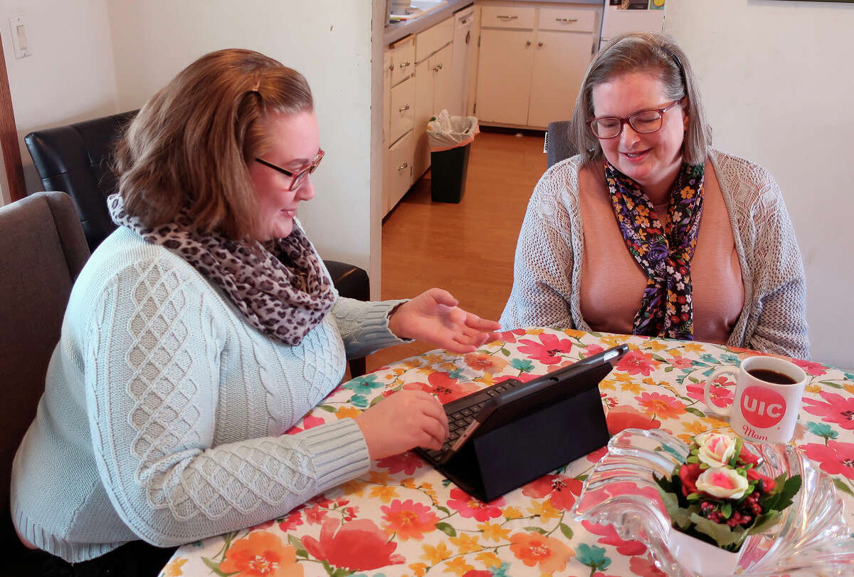 Helen Rottier, 25, shows her mother, Amy Rottier, 50, how she organizes her calendar on her iPad. The two women illustrate the way Gen Xers and millennials differ in how they spent their time on an average day as young adults because of changes in technology and patterns in forming families over the last two decades.