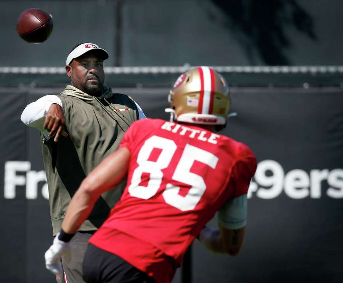 Assistant Head Coach Jon Embree tosses a pass to tight end George Kittle during a San Francisco 49ers team workout in Santa Clara, Calif. on Thursday, Sept. 19, 2019.