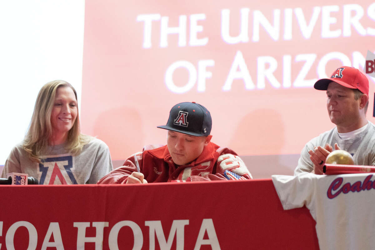 Coahoma High School senior Vance Ott signs his letter of commitment to the University of Arizona’s track program while his parents Marlana and Harold Ott watch during a signing ceremony at the high school’s auditorium on Wednesday, Feb. 2, 2022.